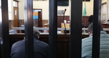 Two men sit side by side in the court dock during proceedings at the Boksburg Magistrate’s Court, as their bail application is heard.