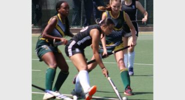 A hockey match in action with four players in the frame.