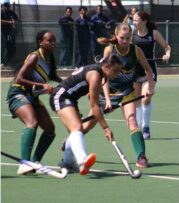A hockey match in action with four players in the frame.