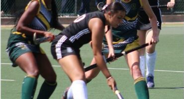 A hockey match in action with four players in the frame.