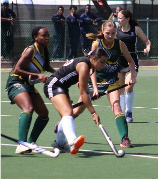 A hockey match in action with four players in the frame.