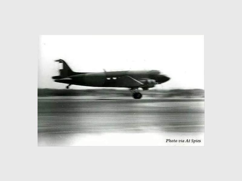 A black and white photo of a Dakota aircraft landing.