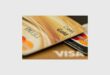 Two gold credit cards lying on top of each other on a table.