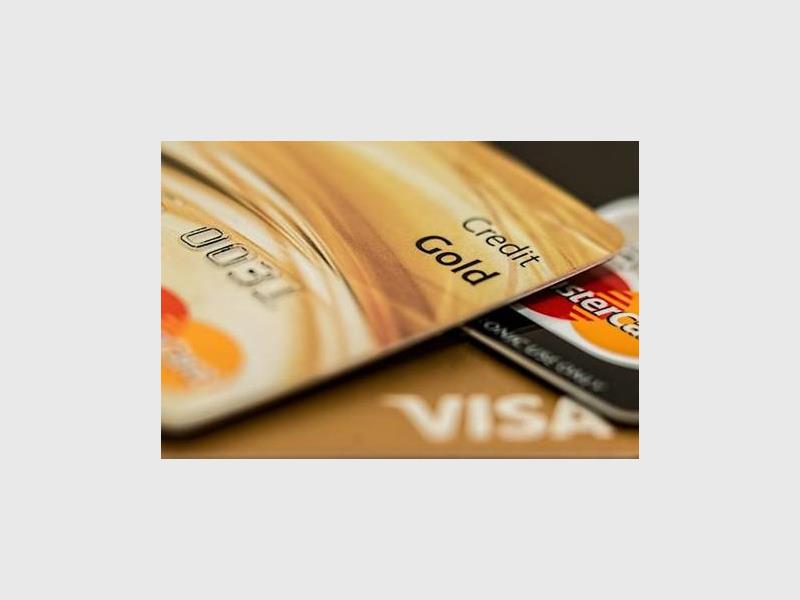 Two gold credit cards lying on top of each other on a table.