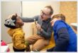 Two doctors examining a small child's mouth using medical instruments.