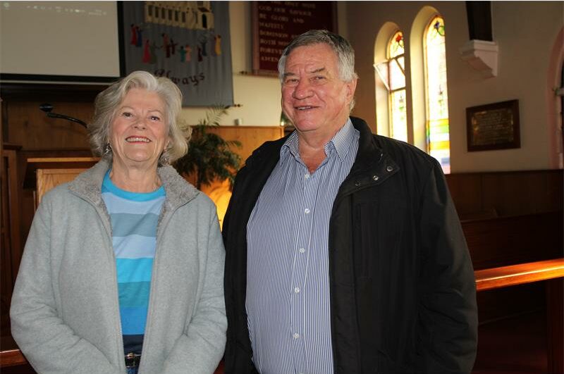 Elderly woman and man standing next to each other