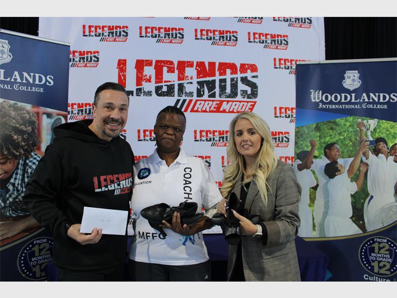 A white male and white female handing over dance shoes to a black male standing between them with a banner reading Legends are Made in the background.