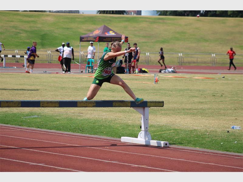 A female athlete taking part in a steeple chase.