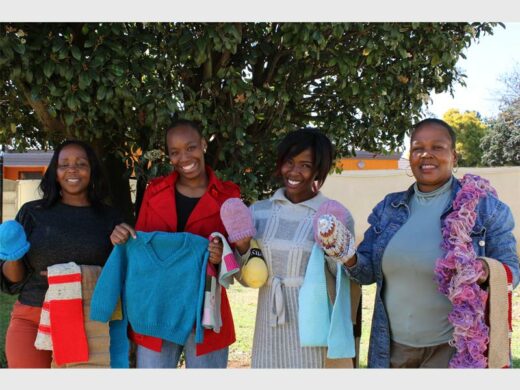 Four woman holding knitted items