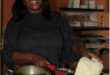 a woman chopping a cabbage in a kitchen