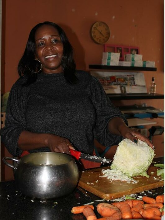 a woman chopping a cabbage in a kitchen