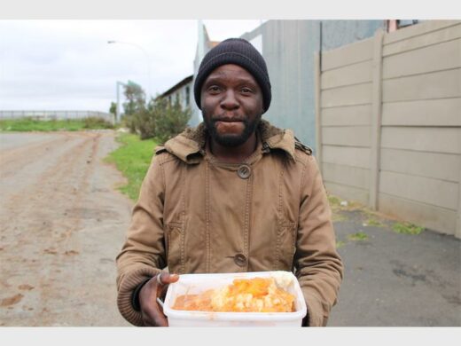 a man holding a container full of meal