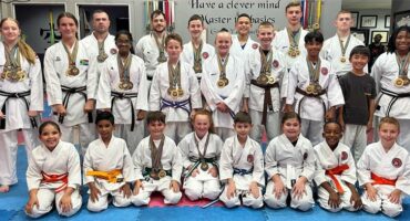 Group of people wearing karate gi's and wearing medals