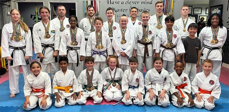 Group of people wearing karate gi's and wearing medals