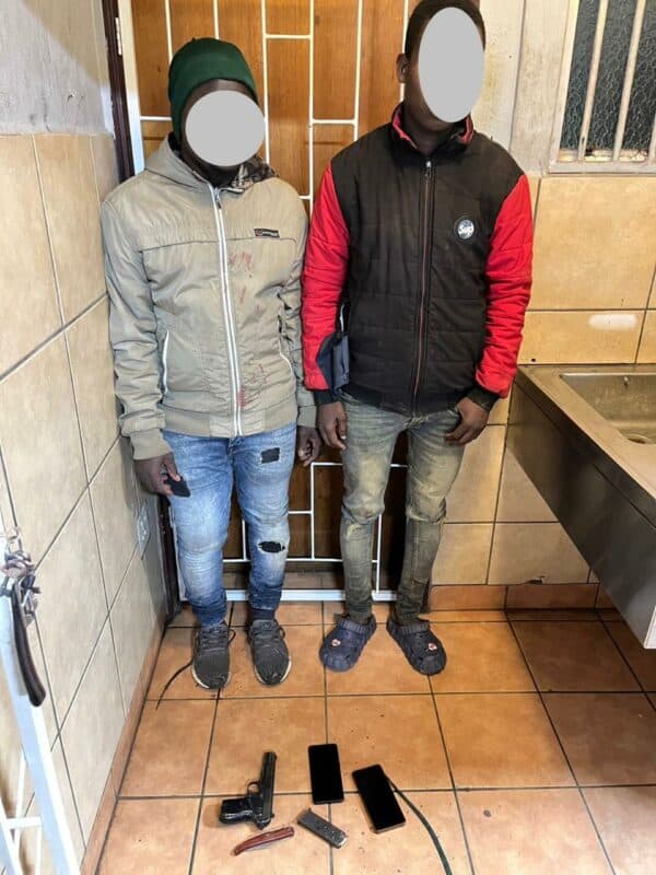 two men pictured with the firearm, knife, magazine and cellphones