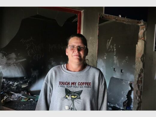 a woman standing next to a vandalised building