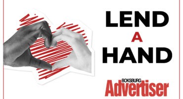 A black and white image with the words Lend a Hand and the Boksburg Advertiser logo in the bottom right hand corner and an image of hands forming a heart.