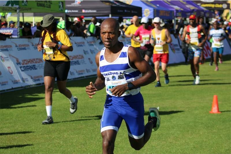 A black male athlete dressed in BAC kit taking part in a marathon.