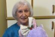 Elderly woman holding a purple stuffed animal