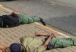 Two uniformed officers laying face down on the pavement