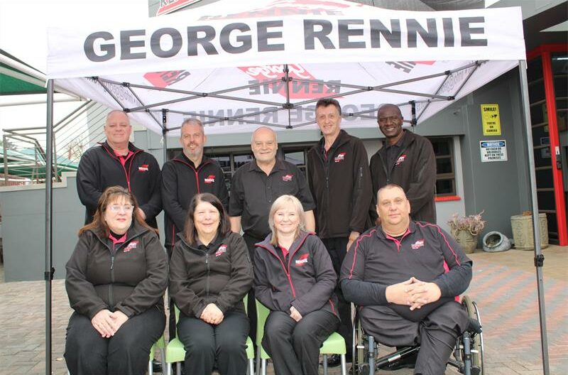 Group of people wearinf matching black jackets sitting under a George Rennie gazebo