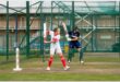A junior and adult cricket player batting in the nets during a training session.