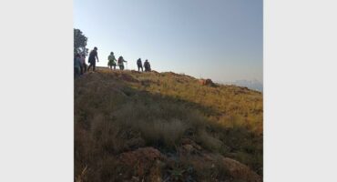 A view of Melville Koppies with a group of hikers against a blue sky.