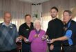 Group of five people, four men and one woman holding medals of honour