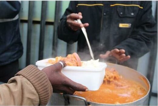 a man serves soup to a needy person