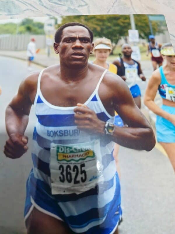 A black male runner in BAC kit and wearing a race number while taking part in Comrades Marathon.