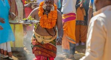 Man in Hindu attire walking over coals