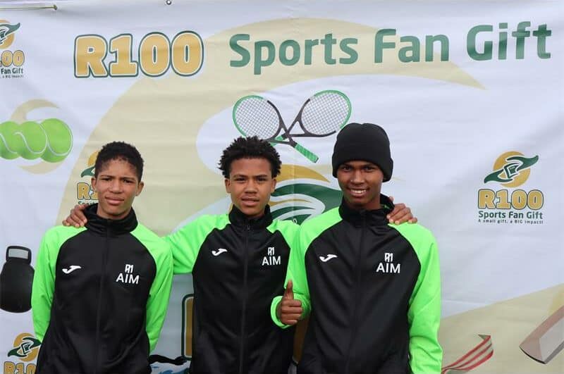 Three boys in black and green AIM kits.