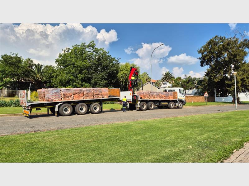 A view of a truck transporting bricks parked in a residential suburb.