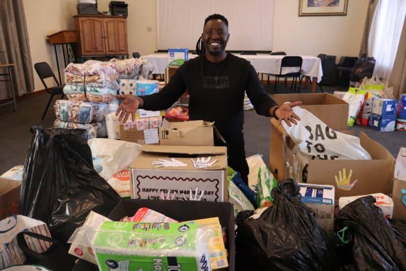 a man with donated items, including food and clothing