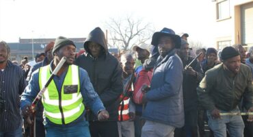 Group of protesters holding sticks chanting