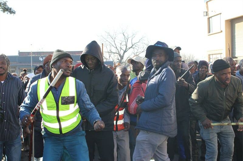 Group of protesters holding sticks chanting