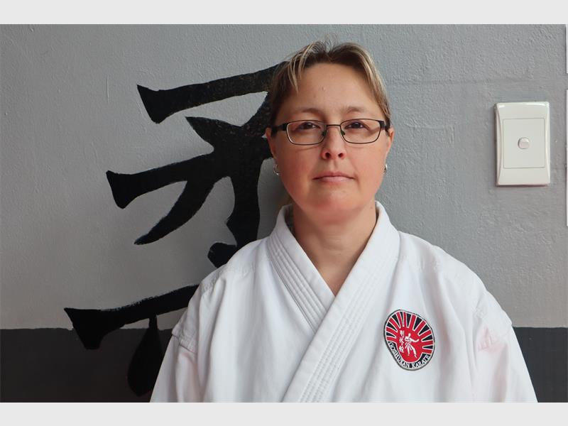lady wearing glasses and white karate uniform