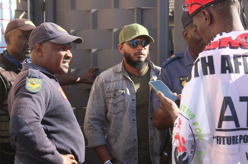Three policeman, one businessman (wearing a green top, green cap, and a jean jacket), leader (wearing a white cape and red hat).