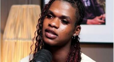 a woman with brown braids and a white top.