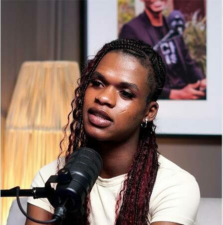 a woman with brown braids and a white top.