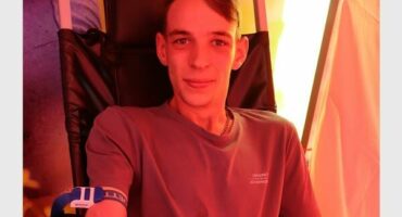 A young white male donating blood.