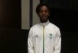 A young black learner wearing a white jacket.