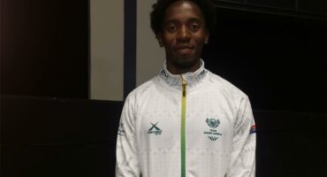 A young black learner wearing a white jacket.