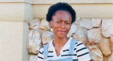 Young black woman standing in front of a wall