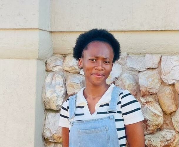 Young black woman standing in front of a wall