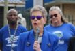 two women and a man in blue political regalia