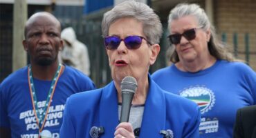 two women and a man in blue political regalia