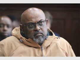 a man wearing a jacket and glasses