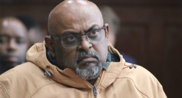 a man wearing a jacket and glasses