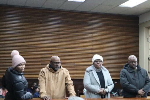 a group of four accused in the dock